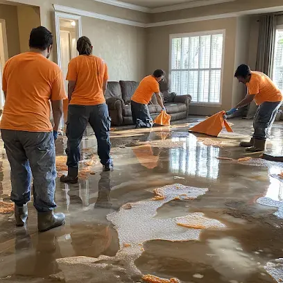 Restoration crew pulling standing water off a flooded floor in a Fort Bend County home