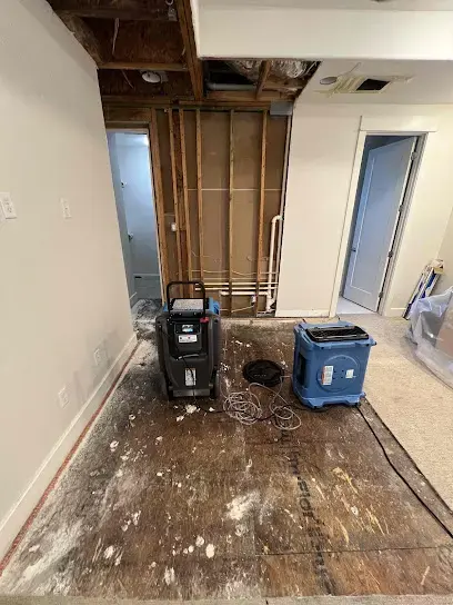 Dehumidifiers set on a stripped floor during structural drying in Sugar Land