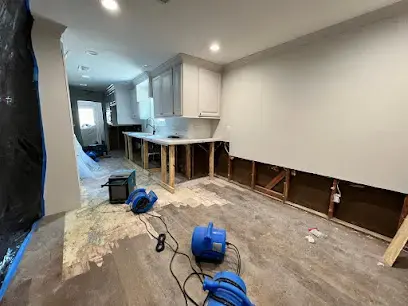 Flood cut and air movers along a kitchen wall in a Sugar Land house