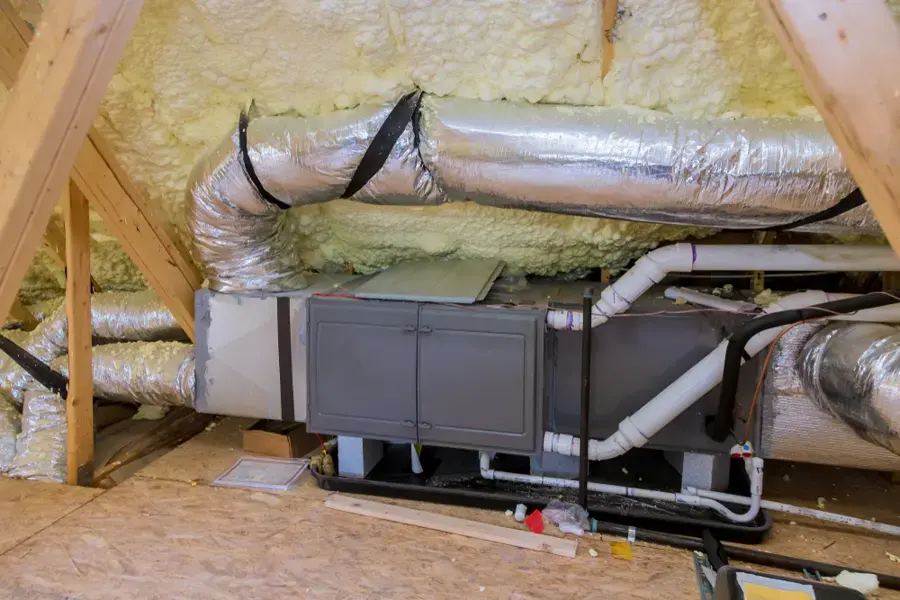 Attic air handler and condensate drain lines above a Sugar Land ceiling