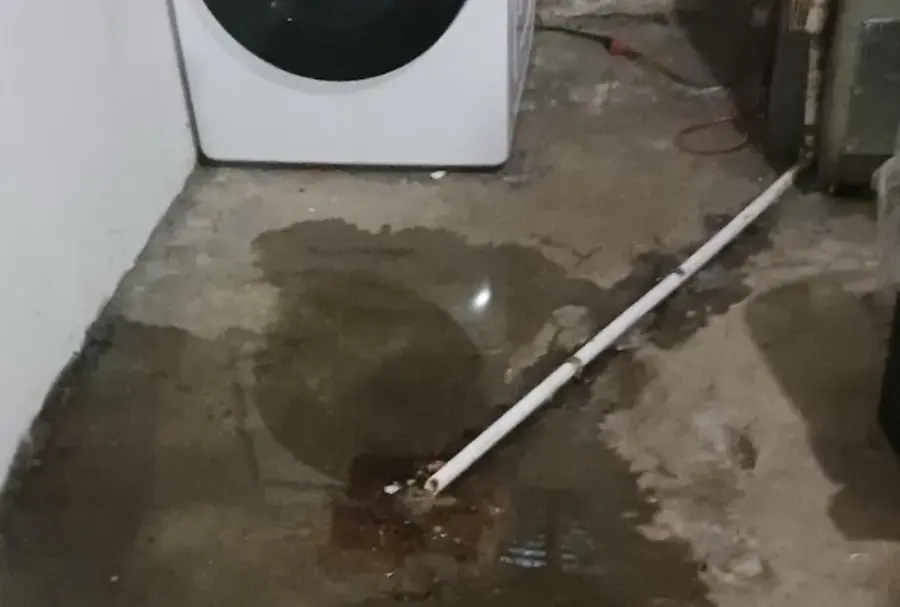 Water spreading across a laundry room floor from a washer supply leak